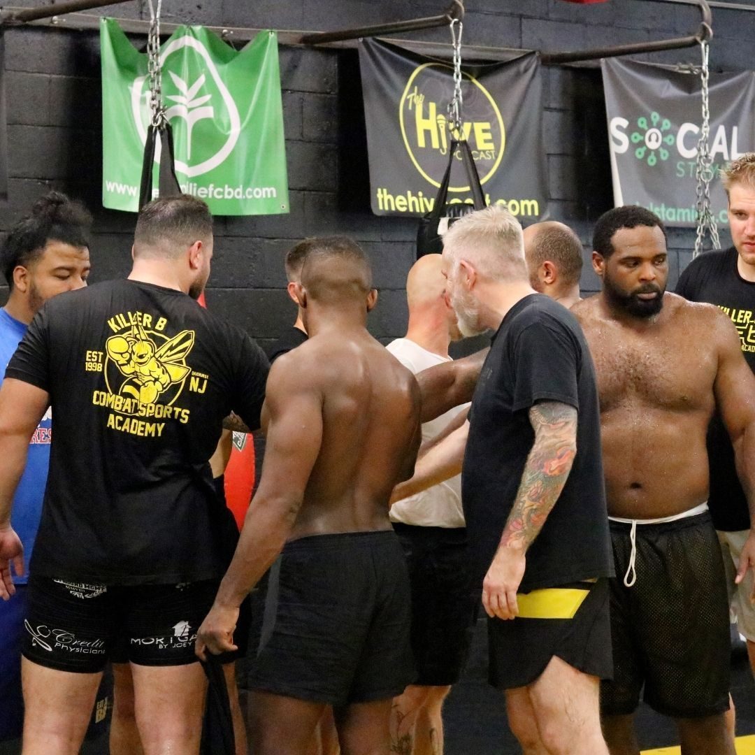 Martial arts training environment at Killer B Combat Academy with students practicing technique.